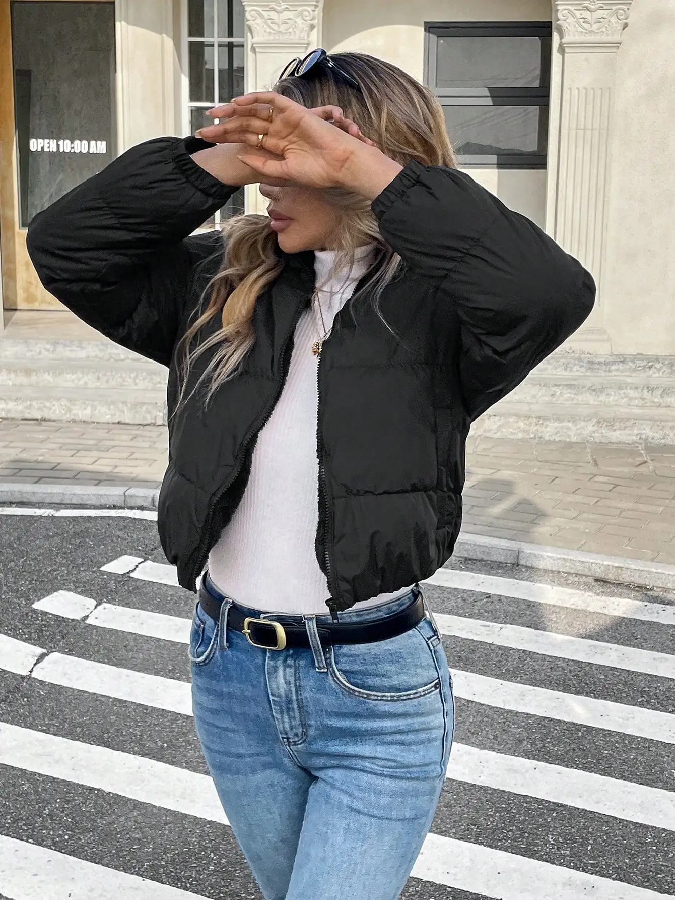 Damska czarna krótka kurtka bomberka puchowa ze stójką i zapinana na zamek z przodu, idealna na zimę.