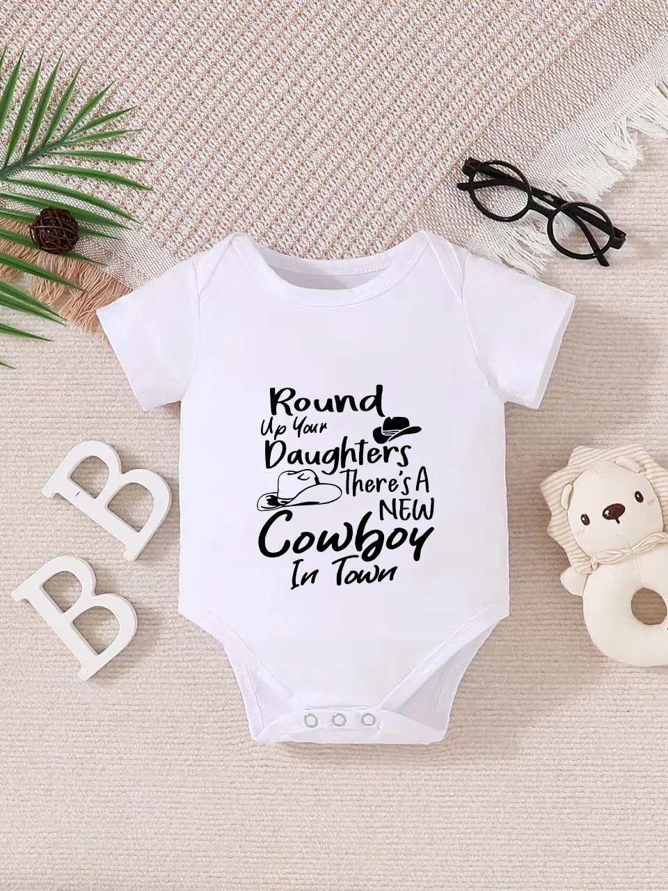 Playful letter-printed baby short-sleeve triangle bodysuit. Button closure for easy dressing, machine washable