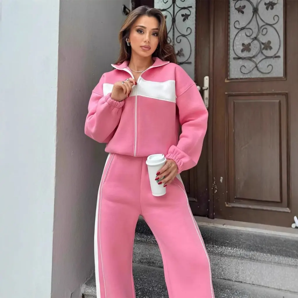 Damski zestaw w stylu casual streetwear: bluzka z wysokim kołnierzem i zamkiem błyskawicznym oraz proste spodnie w kontrastowe paski, dwuczęściowy komplet.