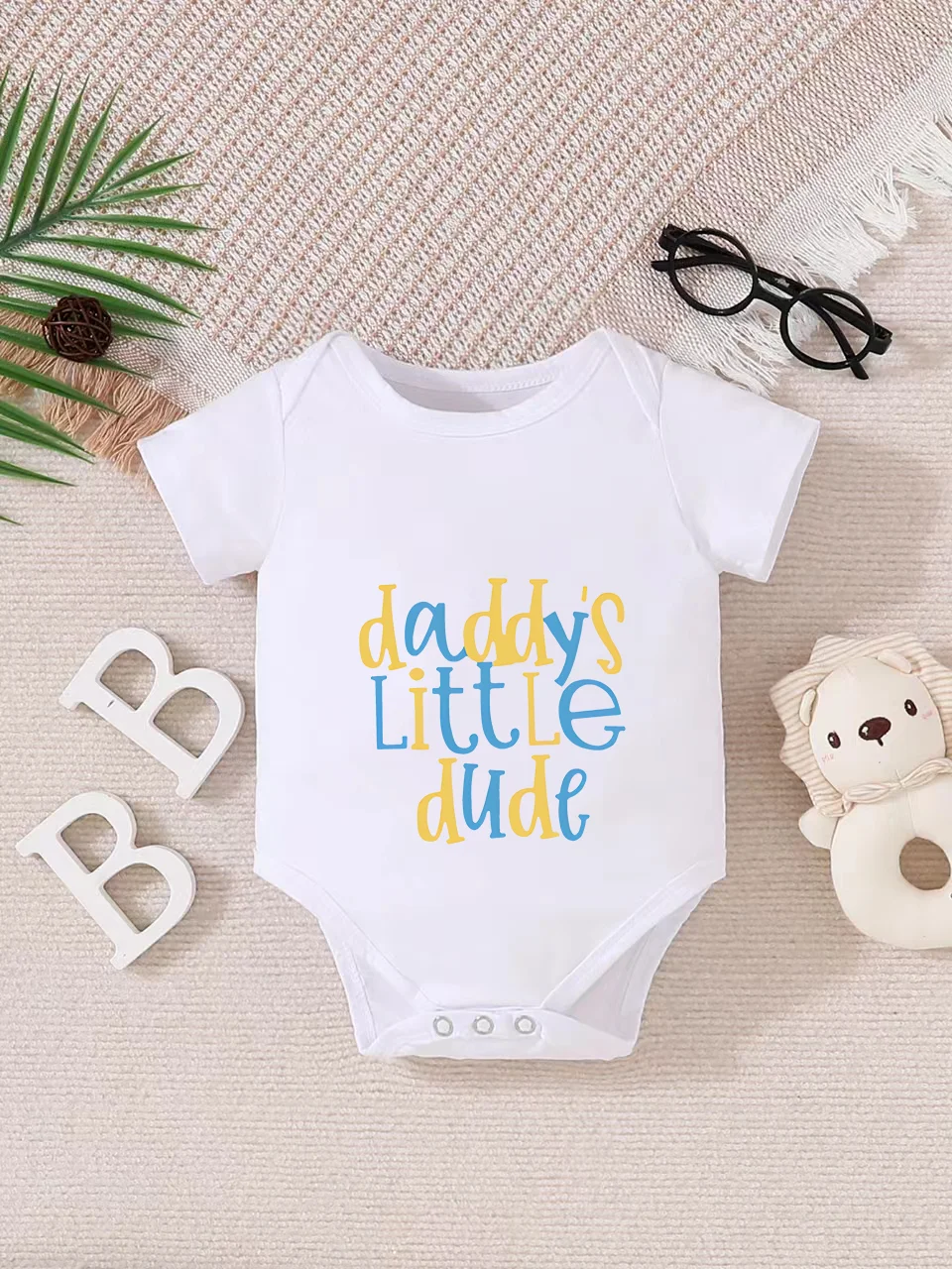 Playful letter-printed baby short-sleeve triangle bodysuit. Button closure for easy dressing, machine washable