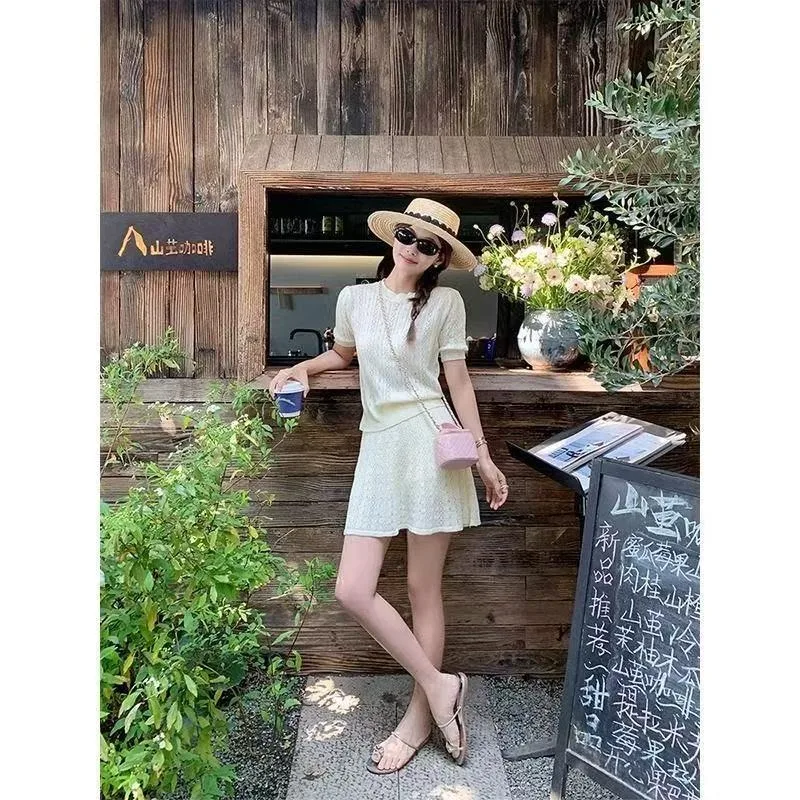 

Элегантный комплект из двух предметов: укороченный топ с короткими рукавами и вырезами, юбка. Новый летний стиль. Женский вязаный комплект с юбкой.