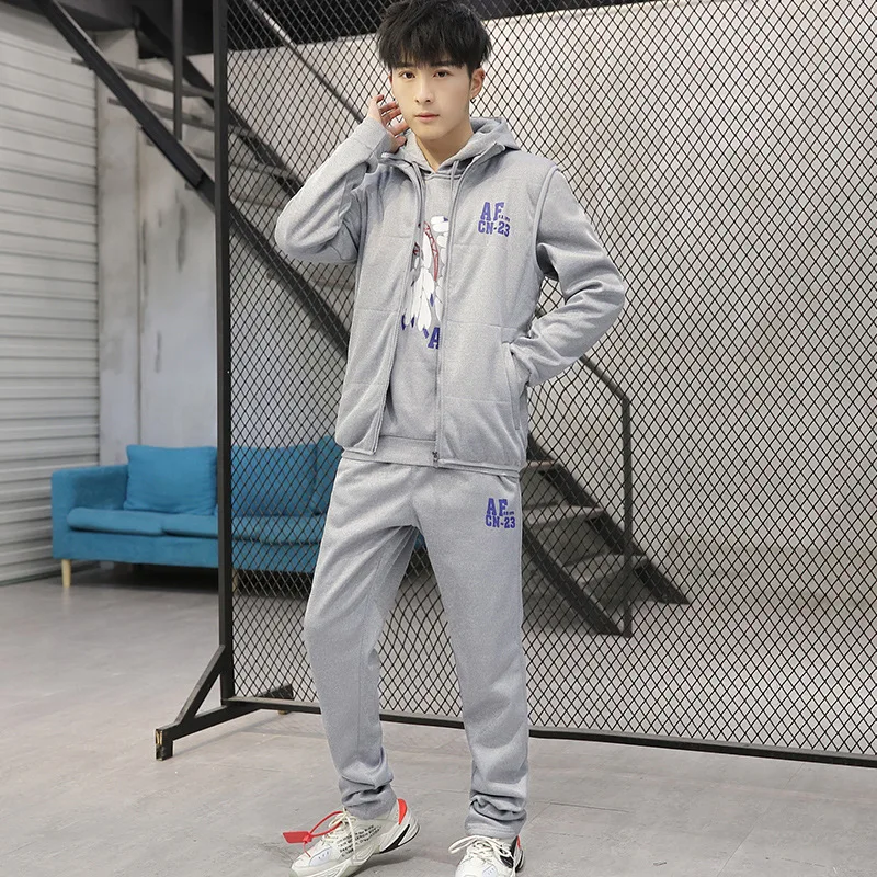 بدلة سميكة على شكل زوجين للرجال. نسخة شبابية من سترة رياضية بغطاء للرأس على الطراز الكوري مع مجموعة من ثلاث قطع. العصرية.