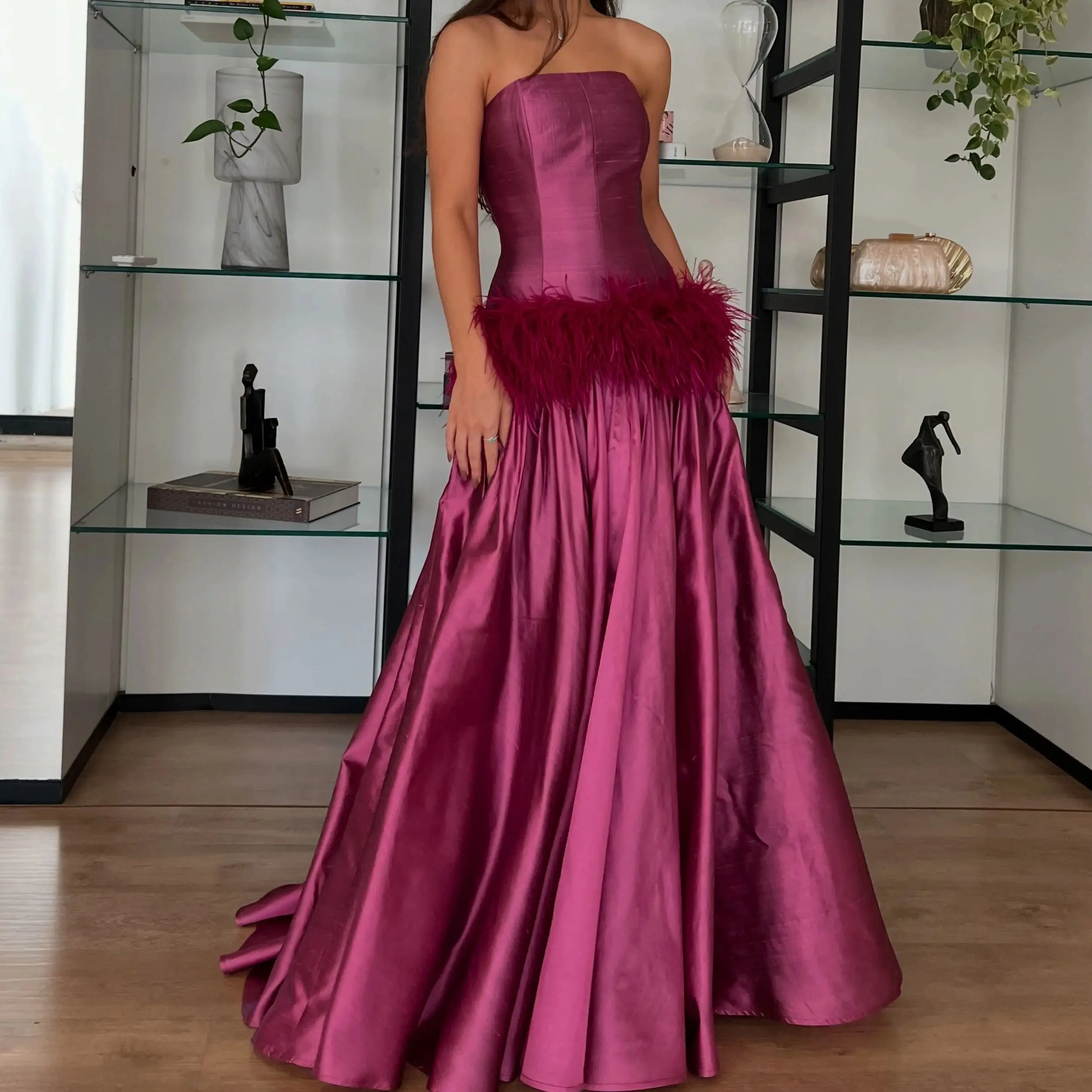Vestido de noche de satén fucsia de lujo, con detalles de plumas, diseño sin tirantes, corte de gala, ideal para eventos formales y bailes, confeccionado a medida.