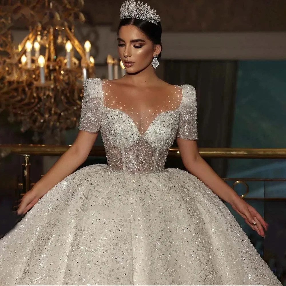 فستان زفاف فاخر على شكل كرة 2026 رقبة شفافة وأكمام قصيرة خرز ترتر فستان زفاف عروس نسائي عربي فيستدوس دي نوفيا