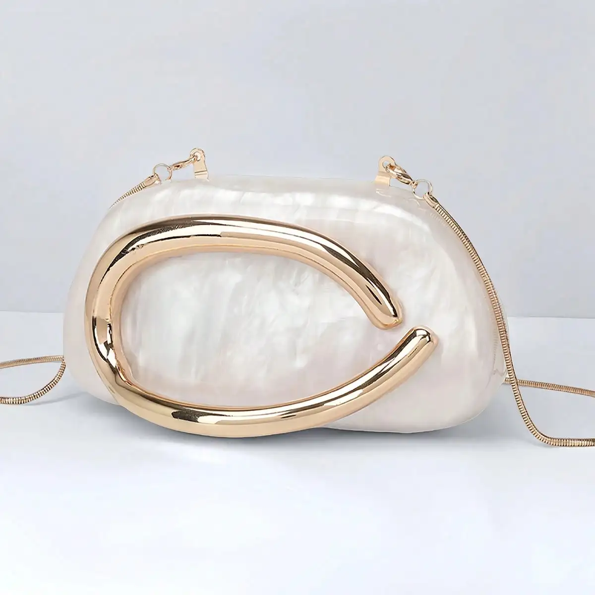 

Перламутровый акриловый клатч с золотой металлической рамкой для вечерних мероприятий
