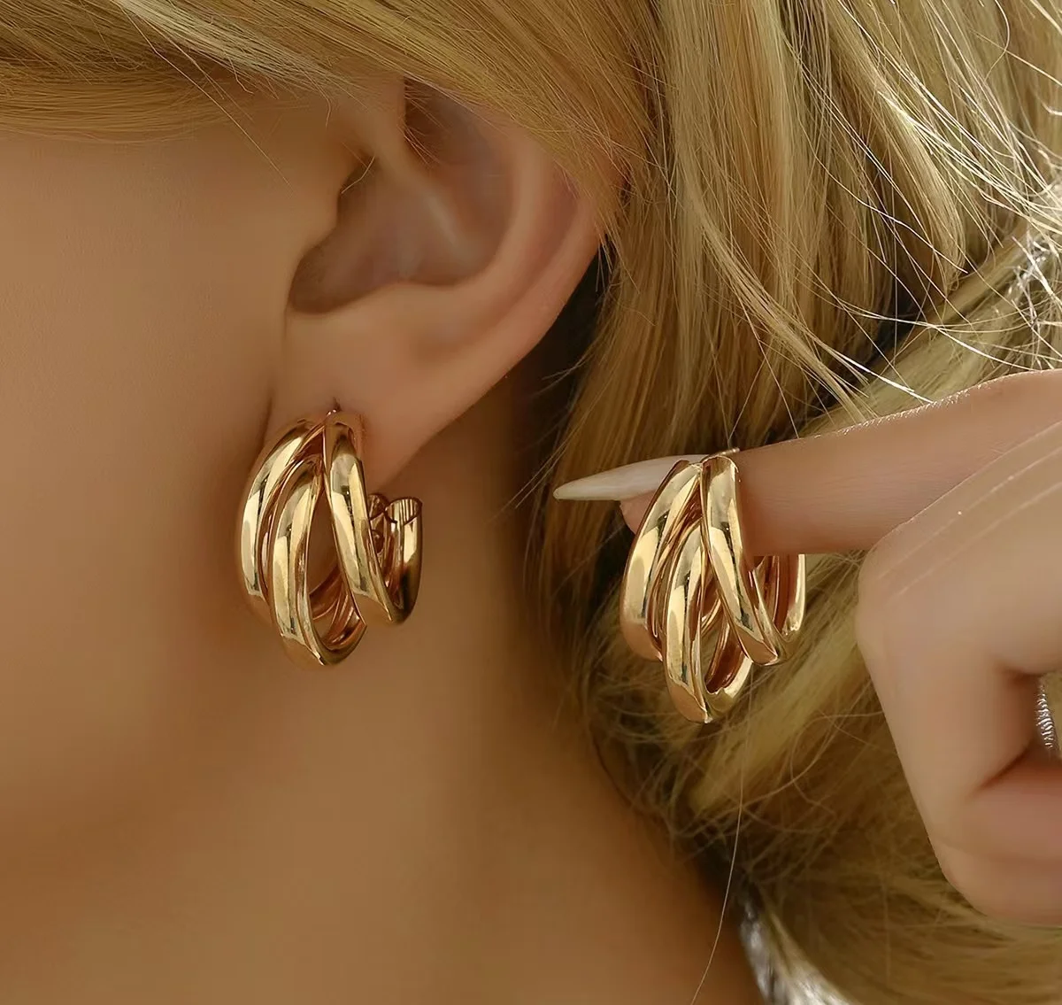 أقراط دائرية ذهبية للسيدات، مصنوعة من مادة معدنية، تتميز بتصميم هندسي أنيق وعجلي، مما يزيد عن كبيرة وفاخرة