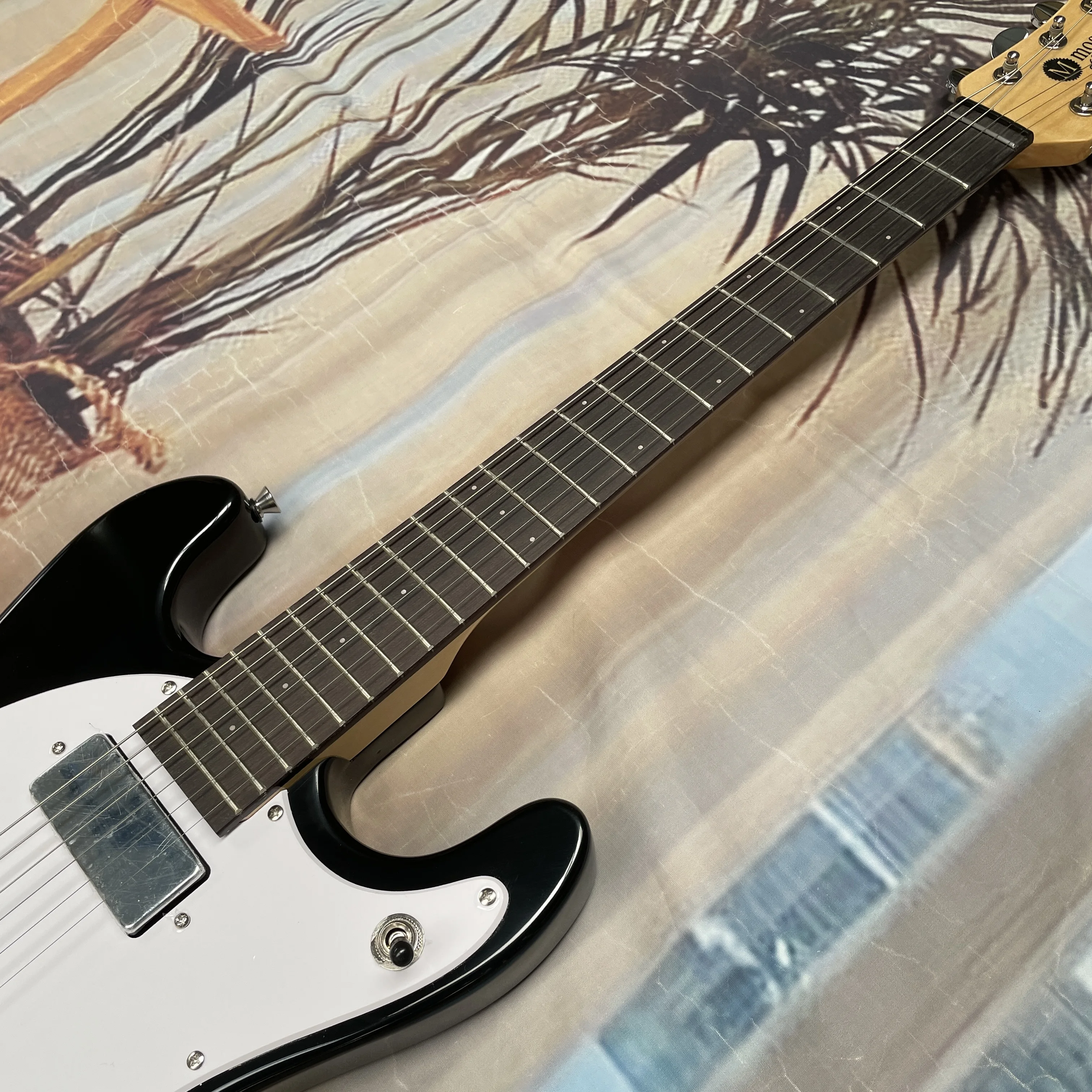 Black 6-string electric guitar with silver hardware, white pickguard,and rosewood fretboard guitars—ideal for beginners guitarra
