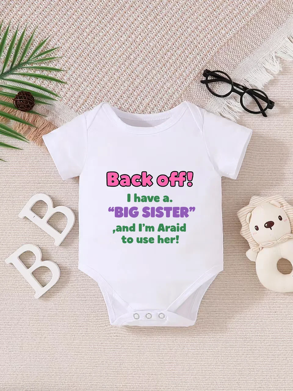 Playful letter-printed baby short-sleeve triangle bodysuit. Button closure for easy dressing