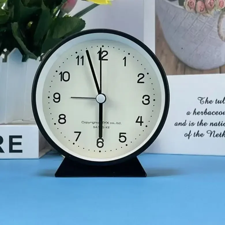 A Cute and Simple Round Bedside Table with A Clock Timer and A Small Student Alarm Clock
