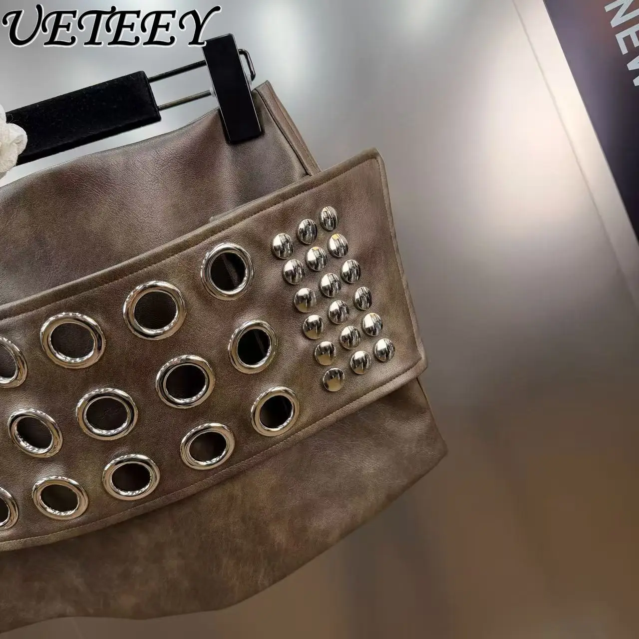 Mini spódniczka z ekoskóry z metalową klamrą, ozdobiona nitami, seksowna, krótka, na wiosnę 2026, z niskim stanem, w stylu hot girl, typu one-step.