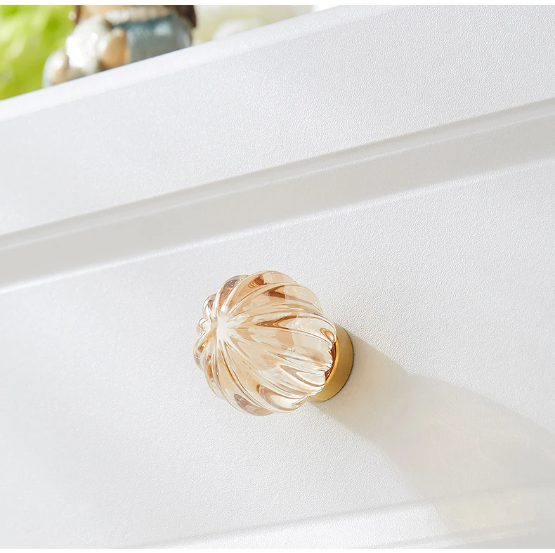Ribbed champagne glass knob on a white drawer front
