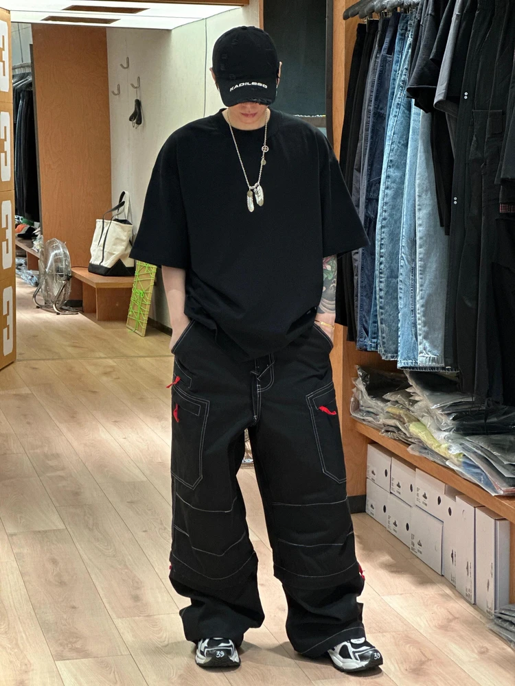 

Свободные рабочие брюки с широкими штанинами, съемными двойными кольцами, вышитым логотипом, контрастной черно-красной строчкой и дизайнерскими элементами.