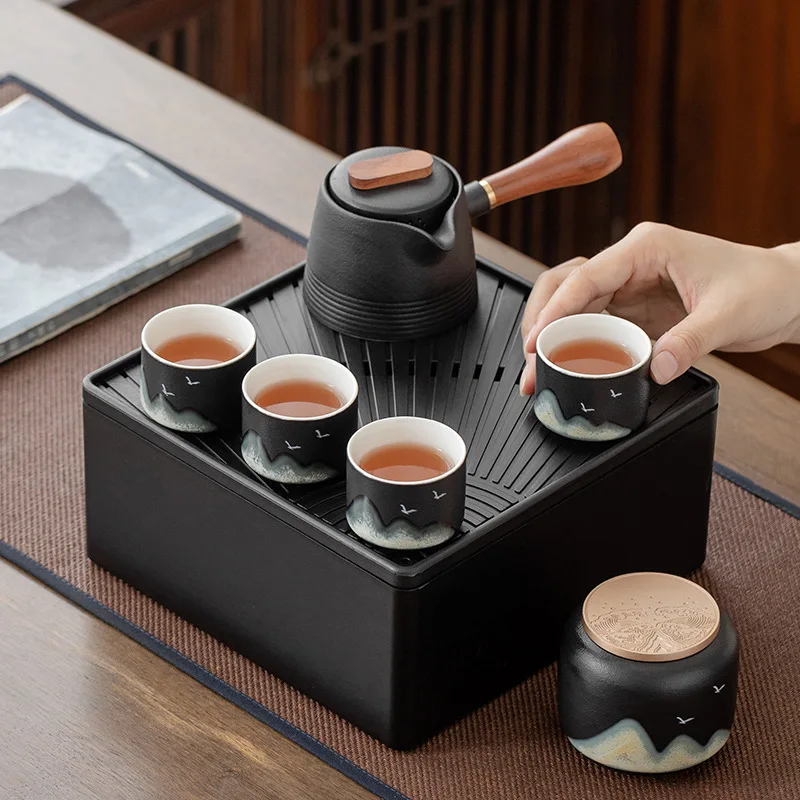 

A pot of four cups of black teapots and tea sets with tea jars, carrying bags and outdoor household gifts.