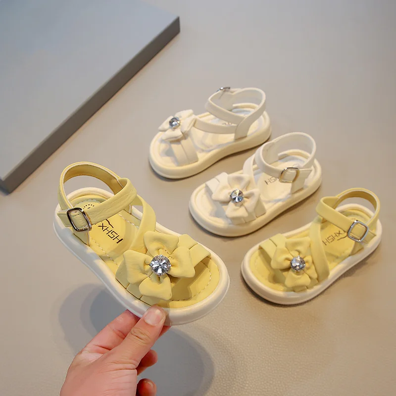 

Новые детские сандалии принцессы со стразами и бантом на нескользящей мягкой подошве с открытым носком для девочек, новинка лета 2025, модные темпераментные сандалии