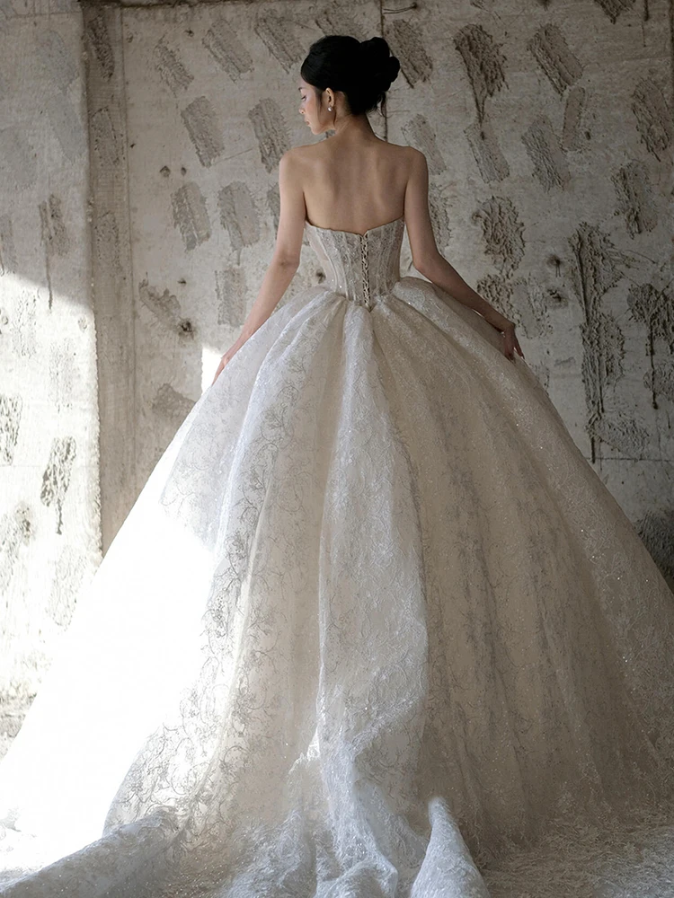 Luxuriöse glitzernde Brautkleider mit langen Ärmeln und trägerlosem Oberteil. Hochzeitskleid für Bräute. Hochwertiges, glänzendes Hochzeitskleid nach Maß