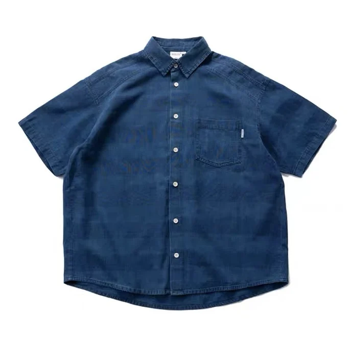 Indigo washed and woven loose French tooling style multi-pocket short-sleeved shirt