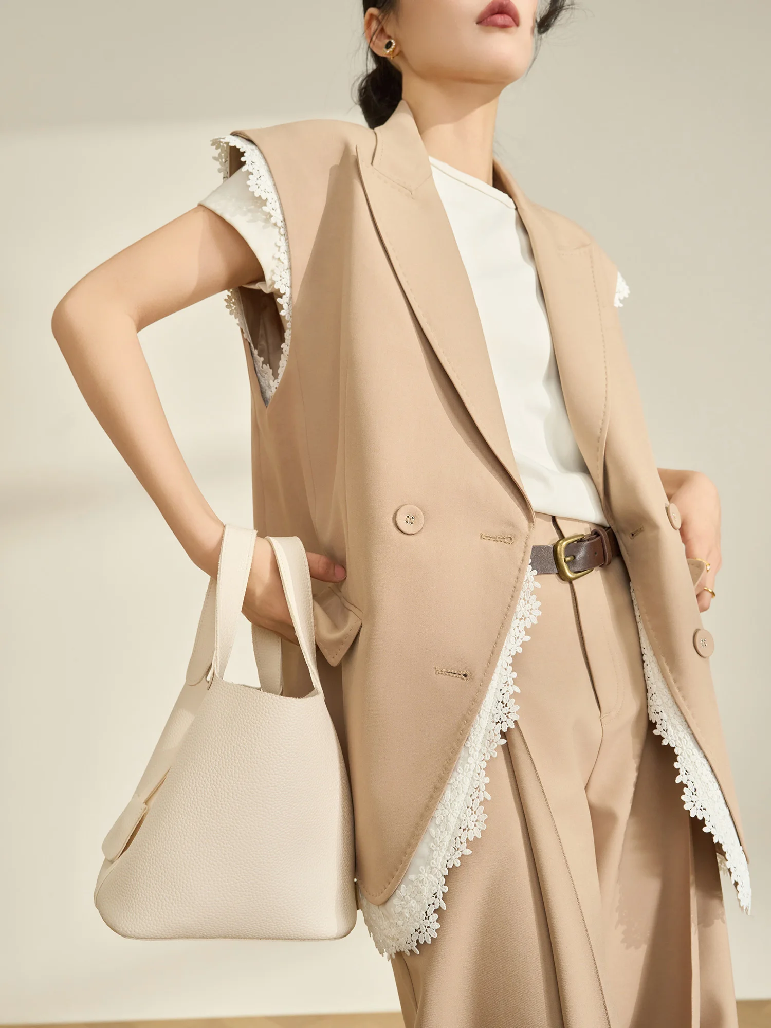 

Комплект для ранней весны: жилет с кружевными вставками цвета хаки и брюки с широкими штанинами. Модный женский повседневный деловой костюм.