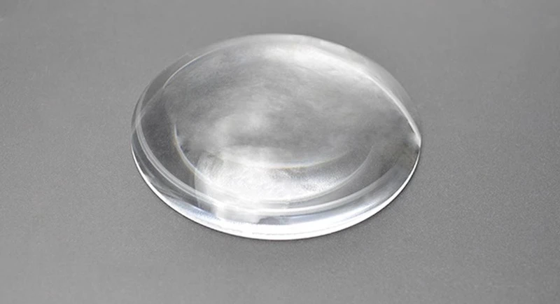 Плоско-выпуклая линза диаметром 70 мм и фокусное расстояние 100 мм. Обработка оптического стекла. Оптическая выпуклая линза.