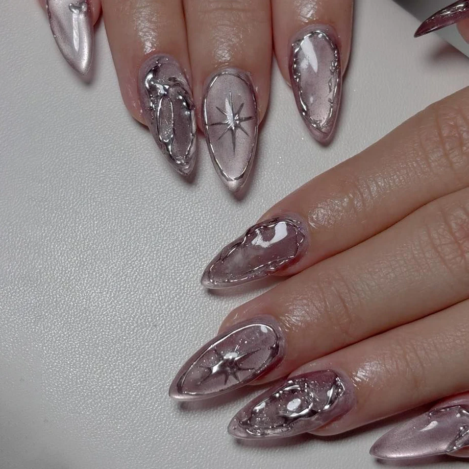 24 handgefertigte Mandel-Press-on-Nägel. Transparente rosa Cat-Eye-Basis mit 3D-Silberverzierung und Sternenmuster. Wiederverwendbarer, trendiger Y2K-Stil für den Alltag