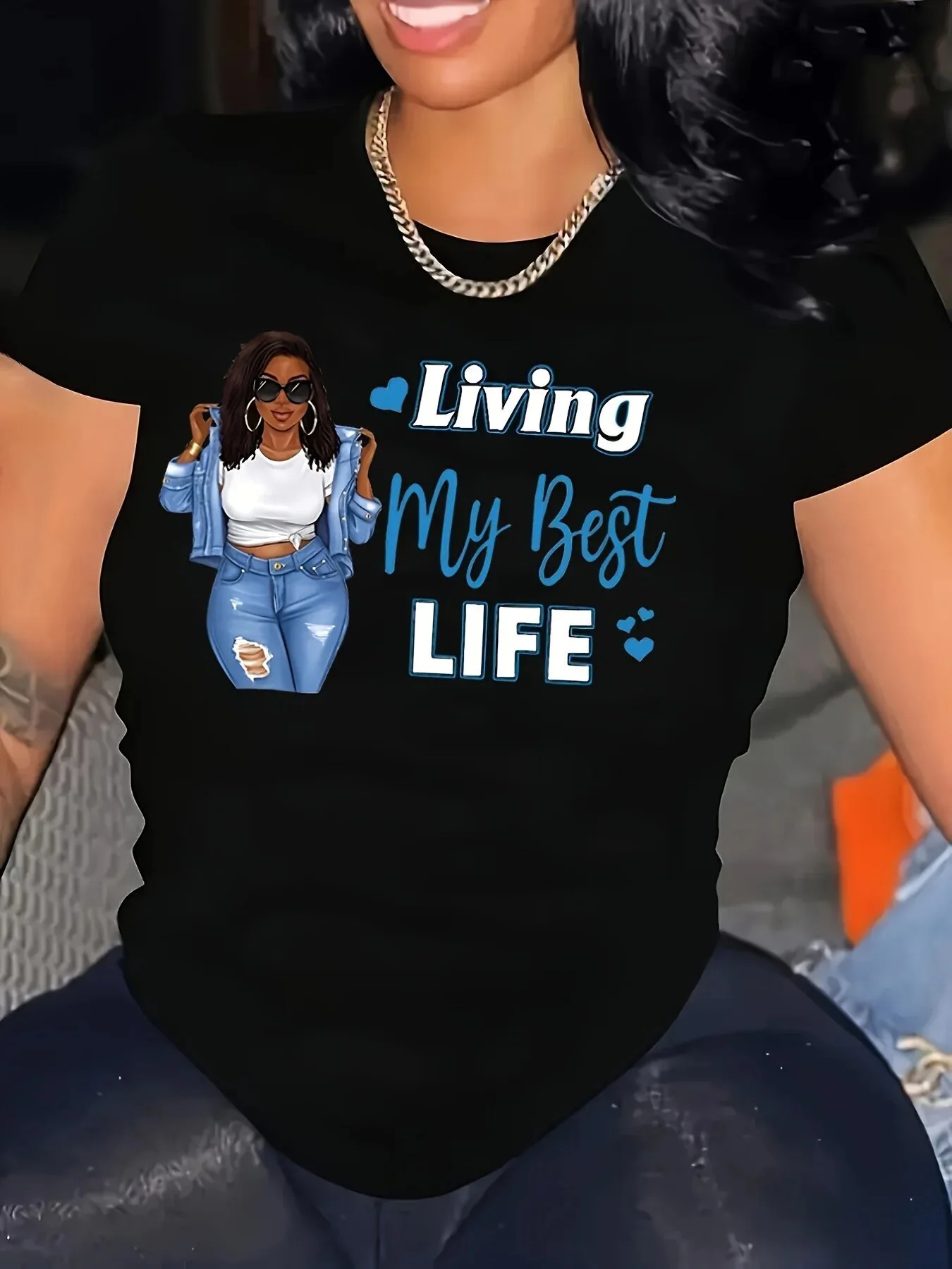 T-shirt nera girocollo da donna - Grafica motivazionale "Living My Best Life" con scritte blu, manica con stampa donna sicura