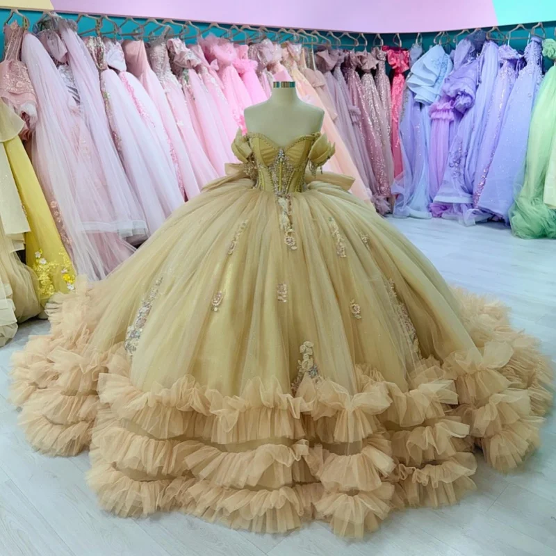 

Платья для квинсеаньеры цвета шампань с открытыми плечами, цветочным кружевом, кристаллами, оборками, аппликациями, длинным шлейфом и бантом. Индивидуальный пошив.