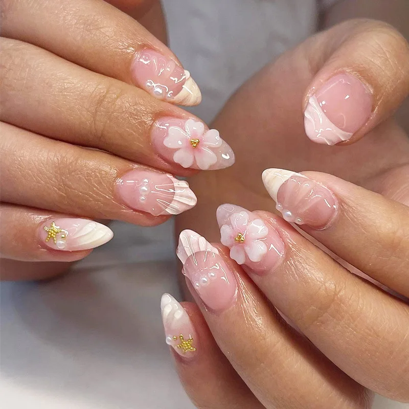 Almond-shaped press-on nails with floral, pearl and shell decorations