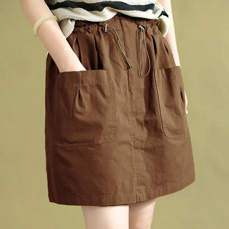 Moda elástica shirring emendado bolsos saias casuais roupas femininas 2025 verão novo solto all-match saias de cintura alta