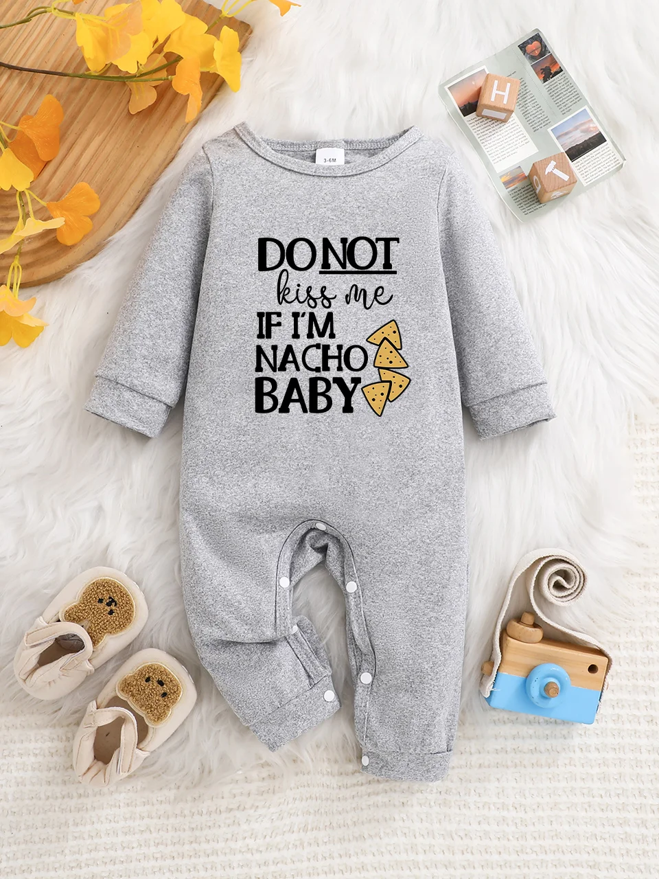 A baby long-sleeved onesie with interesting letter prints. It features a buttoned design for easy putting on and taking off