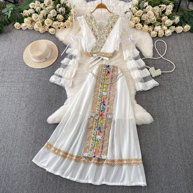 

Элегантный женский комплект в этническом стиле: топ с вышивкой и пайетками, V-образным вырезом и длинными рукавами, а также персонализированная длинная юбка.