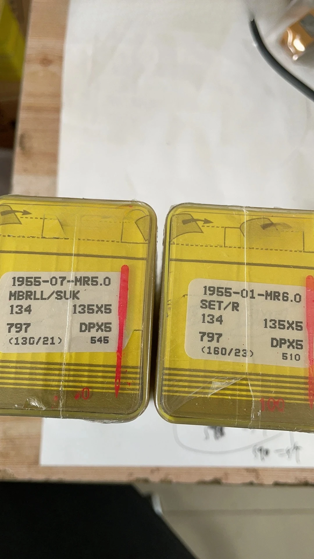 

A box of 100 specialized needles for computerized quilting machines