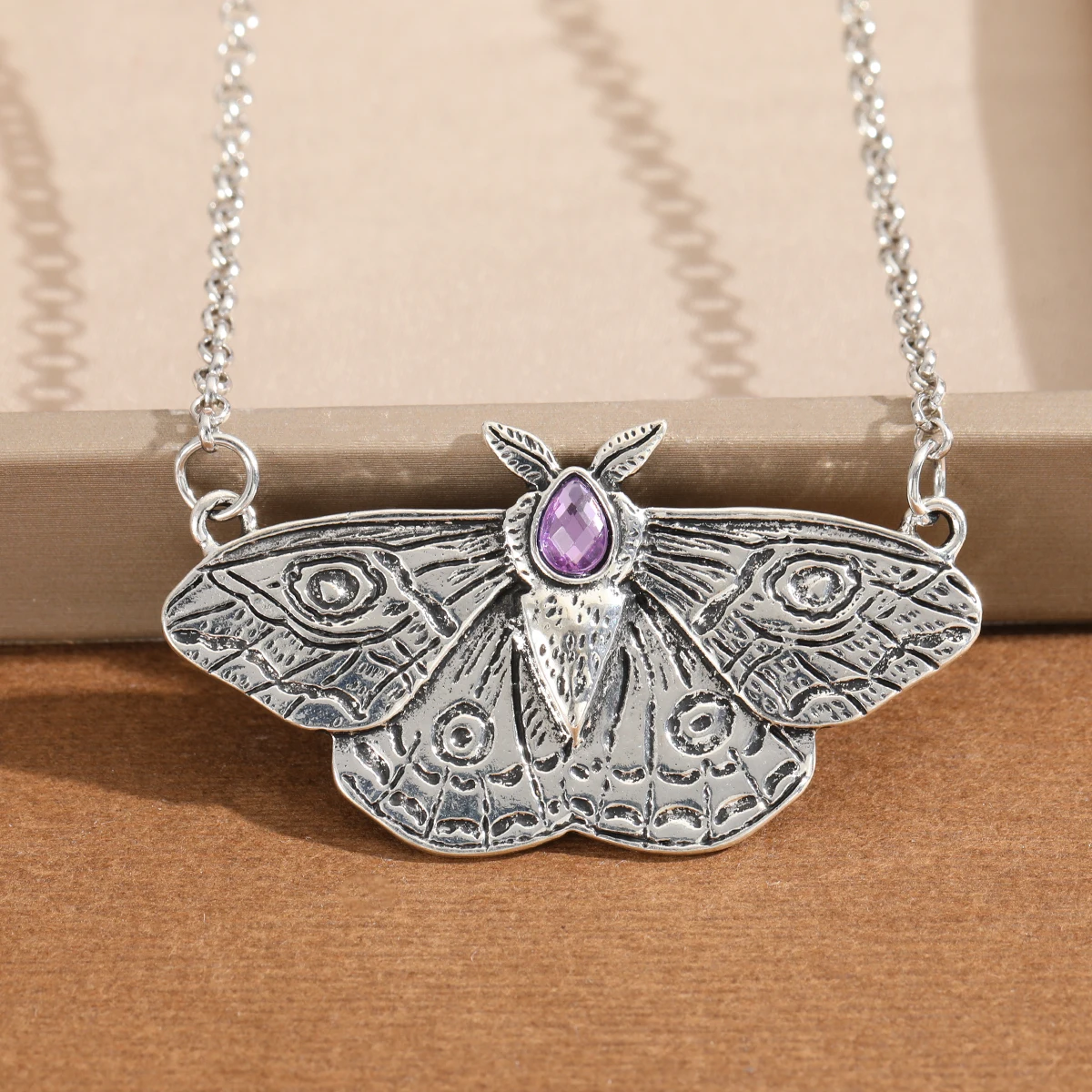Retro-style engraved moth with artificial gemstones pendant necklace for ladies, suitable for parties and gatherings.