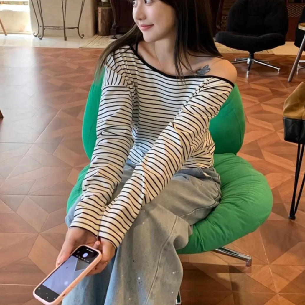 قميص نسائي بأكمام طويلة للربيع والخريف بتصميم بسيط بكتف واحد وياقة مشقوقة مع تفاصيل أزرار وخطوط، مناسب للارتداء اليومي