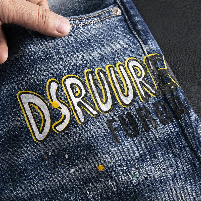 Jeans stampati con lettere di vernice splashate con foro rotto per pantaloni elastici a gamba dritta piccoli slim fit di marca di moda da strada da uomo