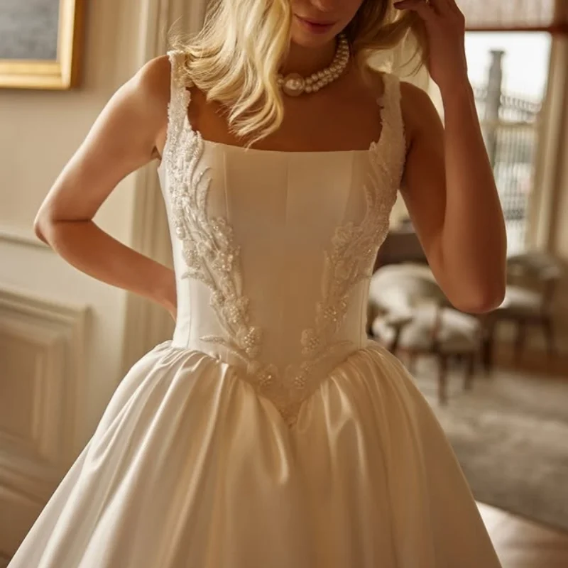 Satynowe suknie ślubne w kolorze kości słoniowej z aplikacjami, z odkrytymi ramionami, spódnica typu A, aplikacje kwiatowe, suknie ślubne szyte na miarę.