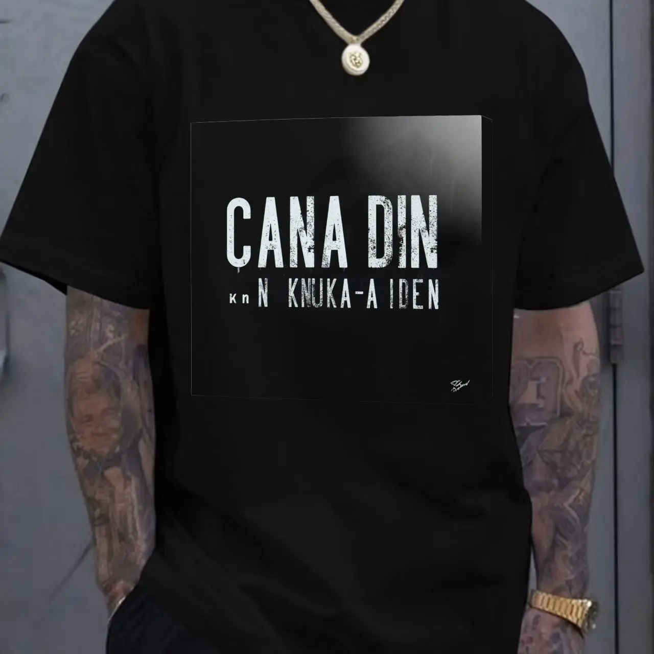 

Белая футболка с круглым вырезом и коротким рукавом с черным прямоугольным графическим текстовым принтом «CANA DIN» — простая повседневная летняя футболка для