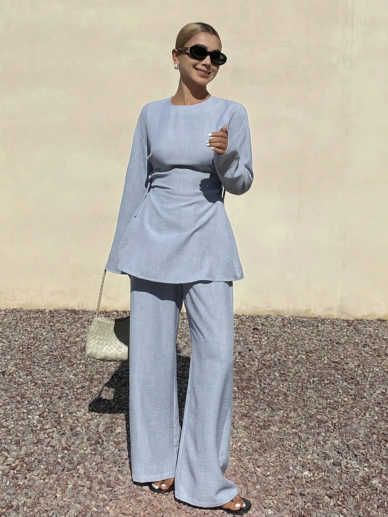 

Женский комплект из двух предметов: однотонный топ с круглым вырезом и длинными рукавами с эффектом складок и широкие брюки.