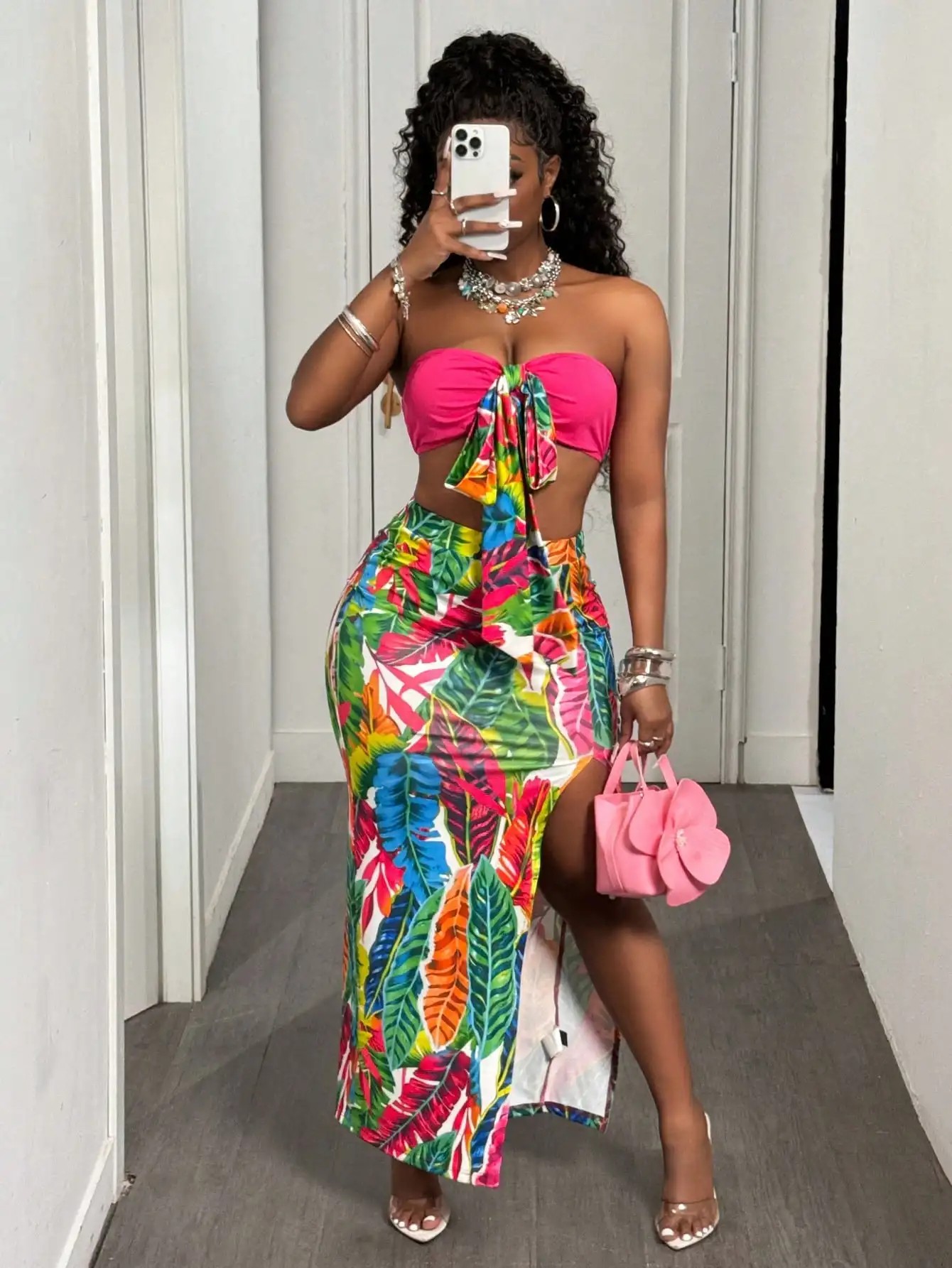 

Яркий комплект из двух предметов с принтом в виде листьев: розовый топ без бретелек и юбка миди с высоким разрезом.