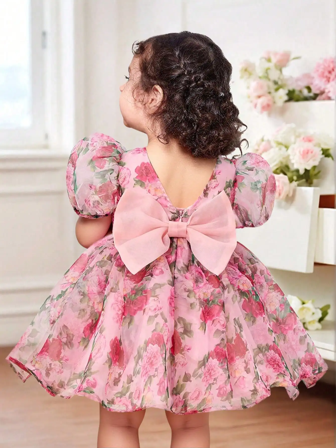 

Розовое платье из органзы для девочки с цветочным принтом, пышными рукавами и бантом на спине