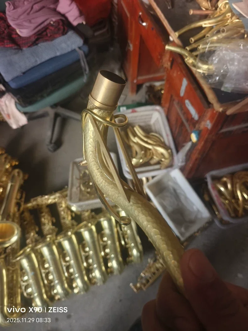 Golden saxophone bent neck, made of pure copper, with hammer patterns on the surface, and the gold plating process is intact