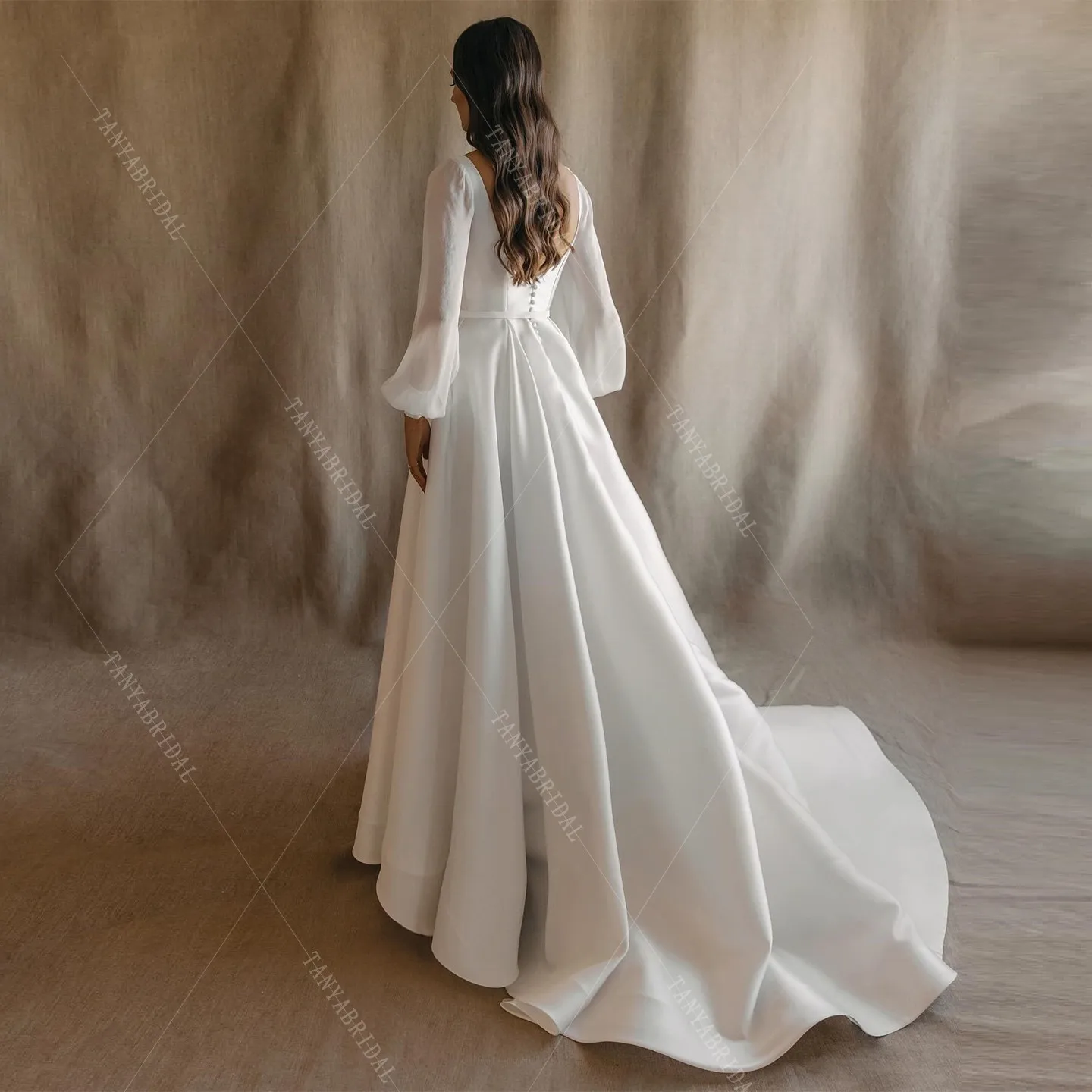 ชุดแต่งงานผ้าซาตินคอเหลี่ยม แขนยาว ทรงเอ ผ่าข้างสูง ชายกระโปรงยาวลากพื้น ดีไซน์หรูหรา