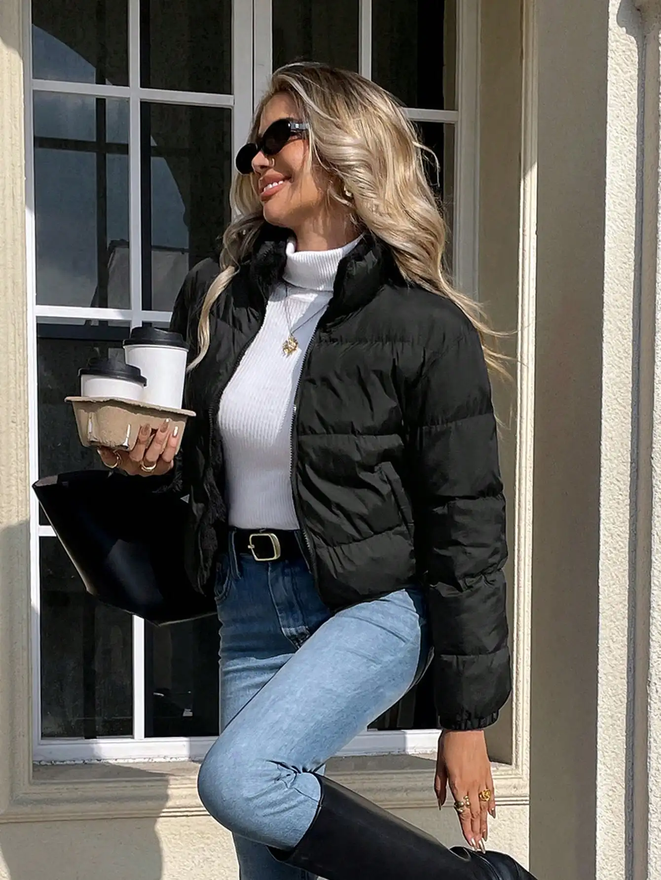 Damska czarna krótka kurtka bomberka puchowa ze stójką i zapinana na zamek z przodu, idealna na zimę.