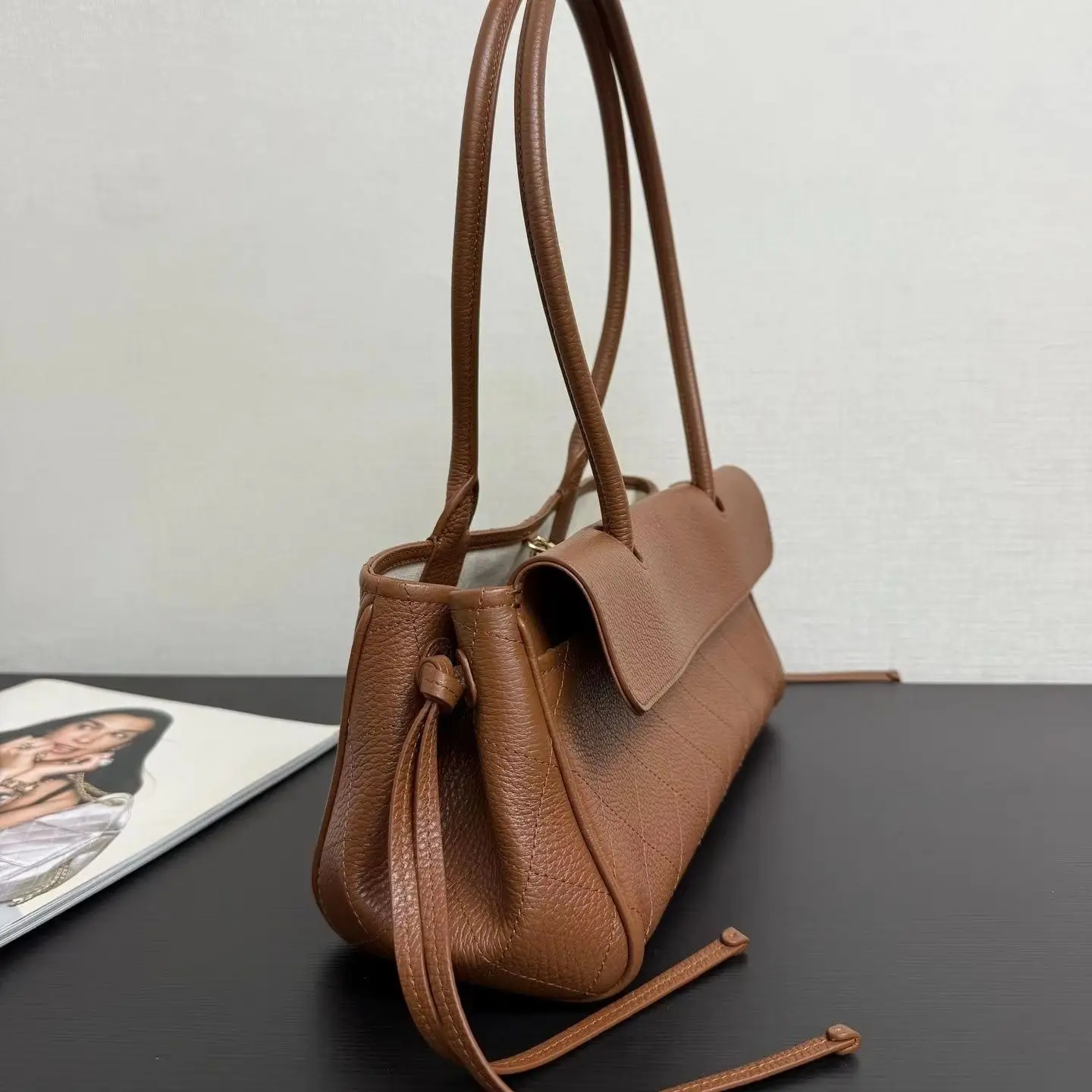 Minimalist vintage leather underarm bag with diamond stitch pattern and soft textured leather.
