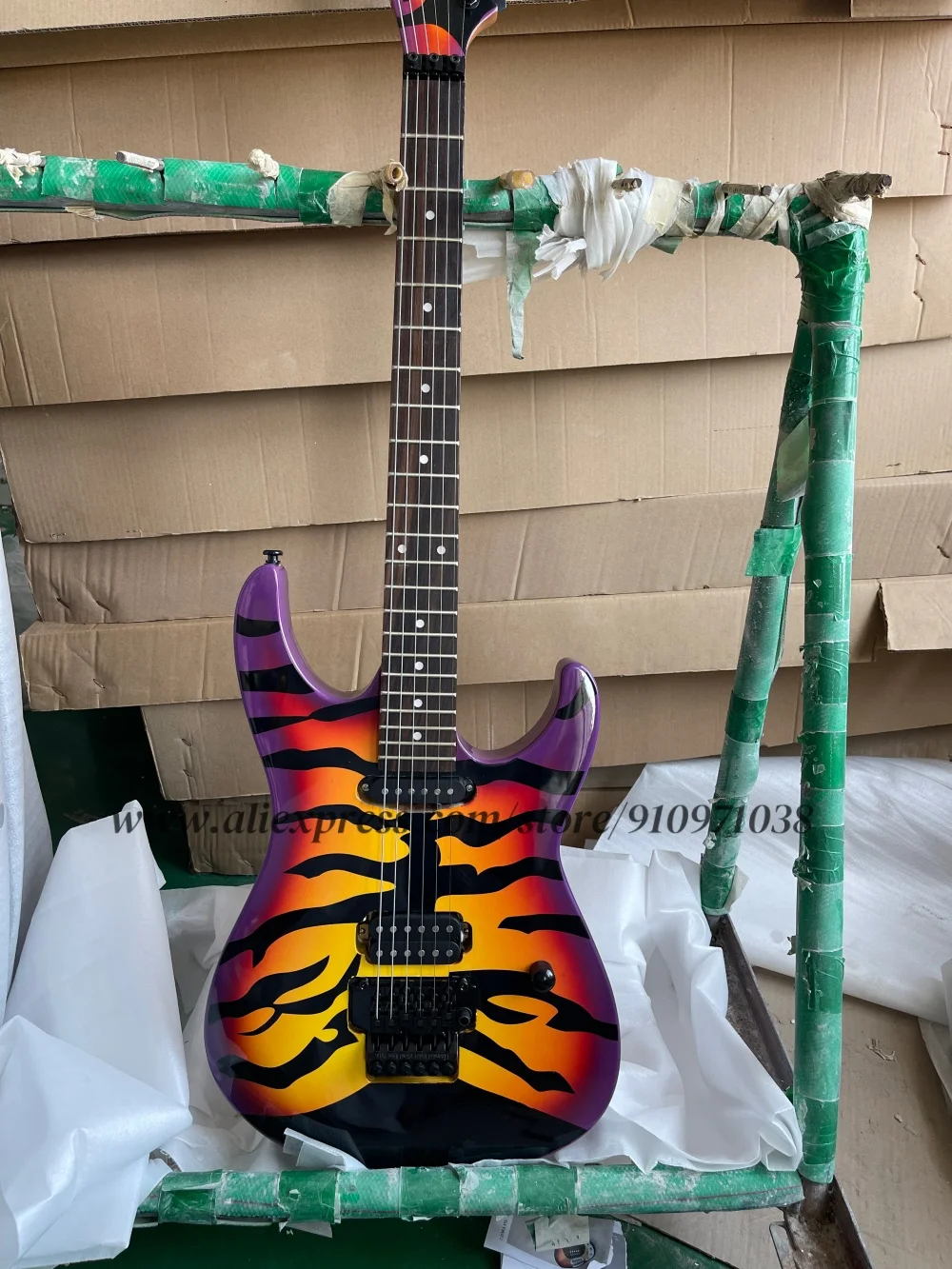 

Желтая гитара с фиолетовым кольцом, бридж тремоло, звукосниматели SH, корпус из цельного дерева с рисунком тигра и кленовым грифом,