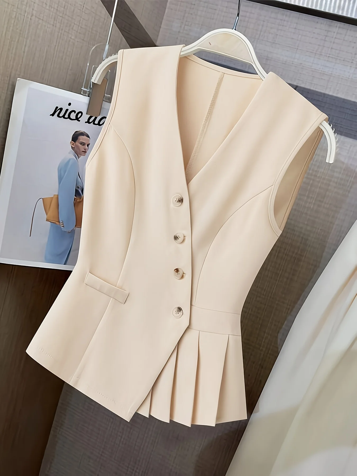 Women’s clothing featuring a V-neck, sleeveless design with pleats at the hem. Perfect for casual or professional settings with