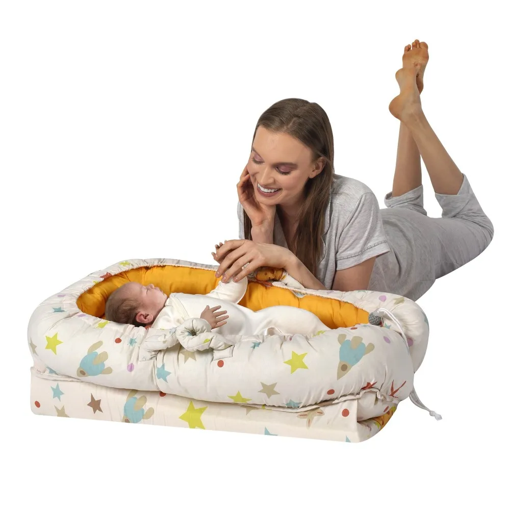 Cream colored rocket patterned mother baby reflux bed