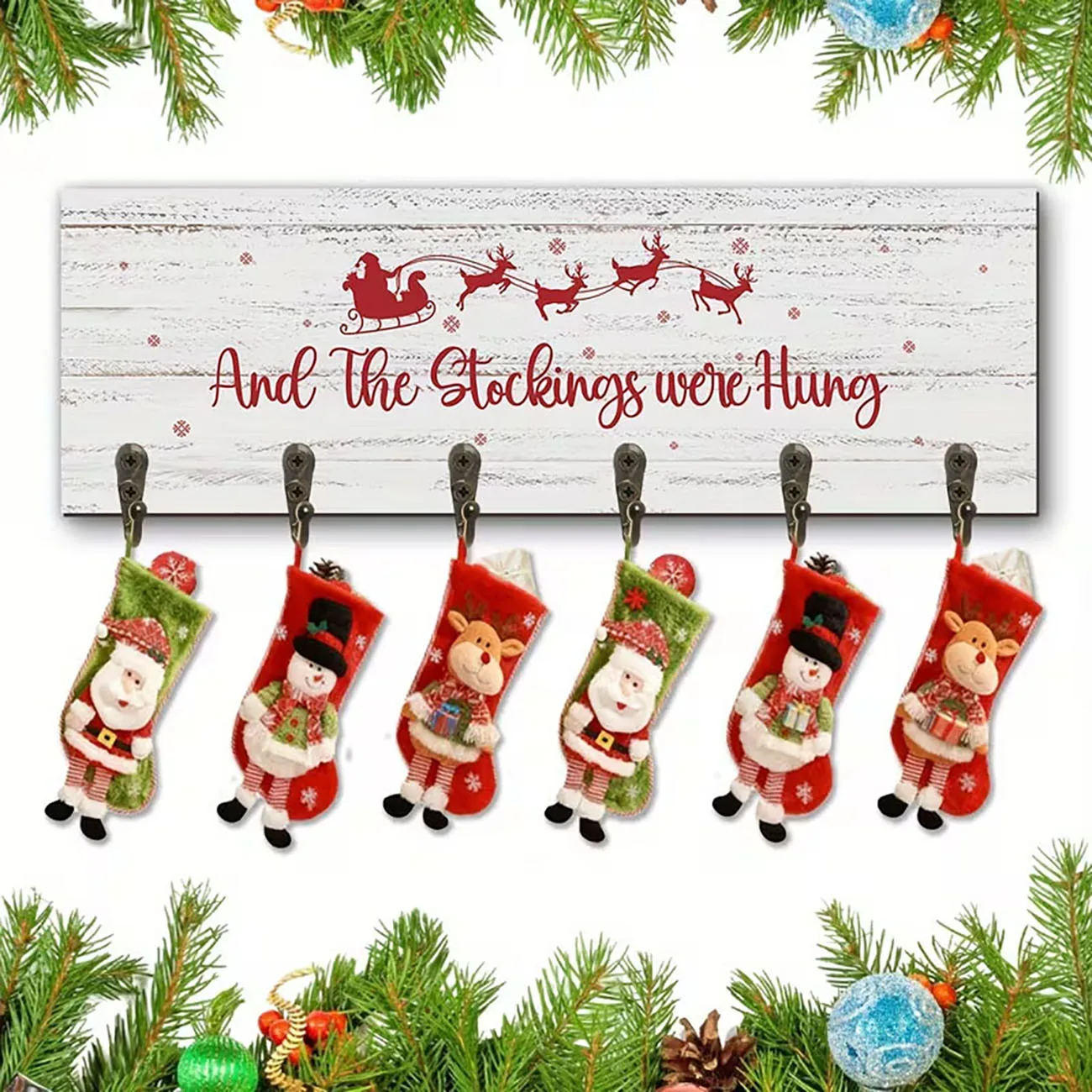 Distressed white wooden stocking holder printed with Santa’s sleigh, six metal hooks, rustic Christmas wall decor.