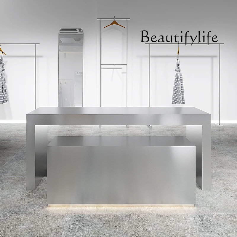 Stainless steel shoes and bags are placed in the middle of the Nakajima table in the clothing store. High and low display stands