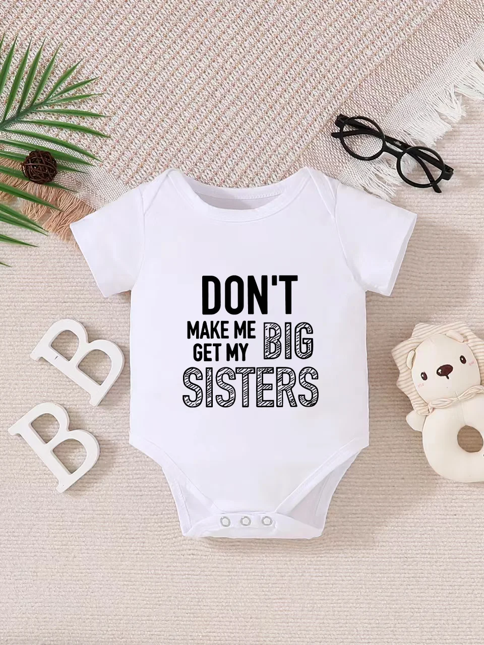 Playful letter-printed baby short-sleeve triangle bodysuit. Button closure for easy dressing, machine washable