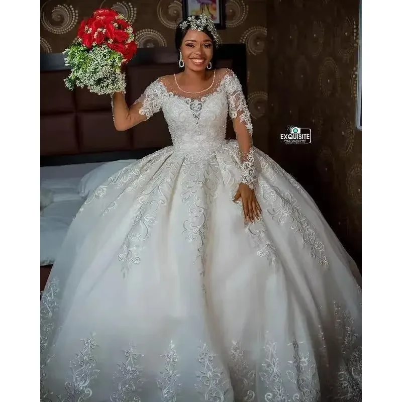 فساتين زفاف مخصصة مقاس كبير 2025 فاخرة بأكمام طويلة مزينة بالدانتيل مطرز برقبة شفافة أفريقية فستان زفاف الأميرة