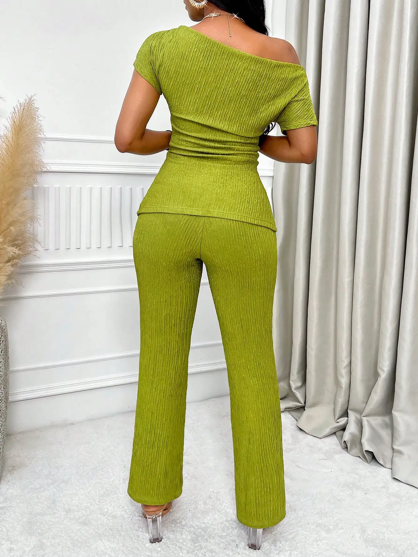 Set top asimmetrico verde con volant e pantaloni a zampa svasata, completo estivo casual in due pezzi per donna